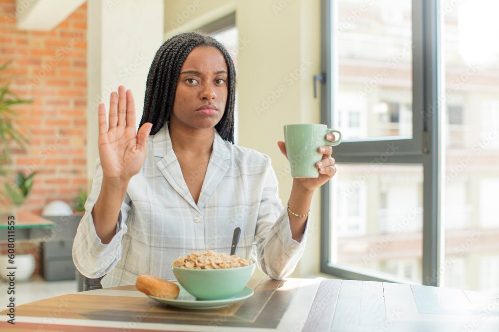 black afro woman looking serious showing open palm making stop gesture. breakfast concept black afro woman looking serious showing open palm making stop gesture. breakfast concept