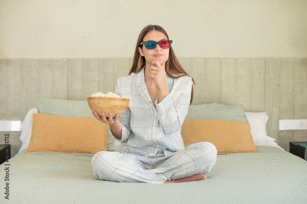 young pretty woman smiling with a happy, confident expression with hand on chin. popcorns and movie concept young pretty woman smiling with a happy, confident expression with hand on chin. popcorns and movie concept