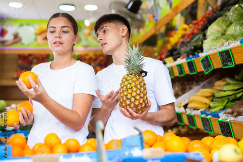 Young husband and wife choose fresh fruit together in a grocery supermarket