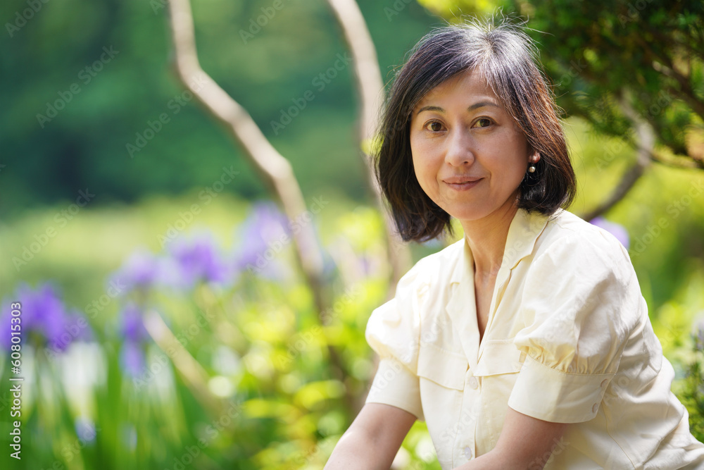 庭にたたずむ素顔の中年女性