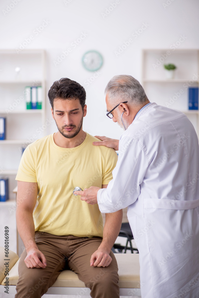 Young male patient visiting old male doctor Young male patient visiting old male doctor