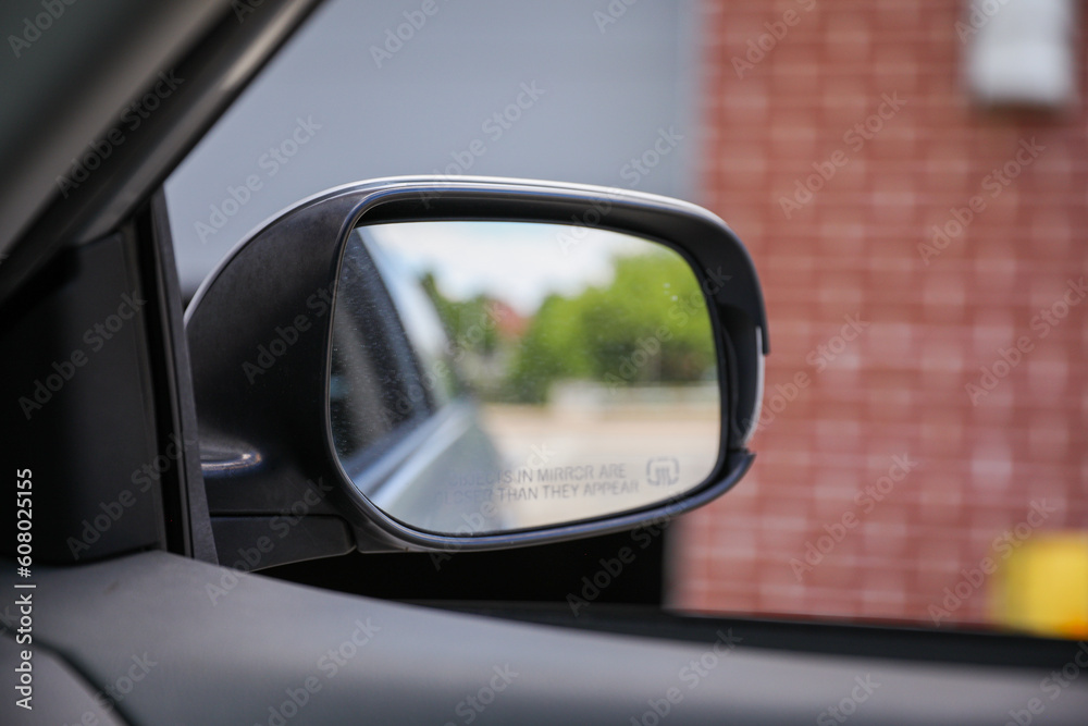 Car side mirror represents reflection, awareness, safety, and the visual extension of the driver's field of view