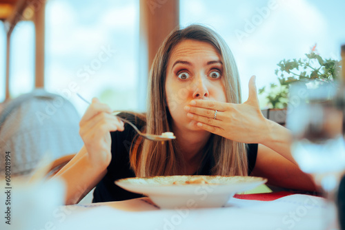 
Woman Eating Soup in a Restaurant Feeling Sick
Sick girl feeling unwell after eating contaminated food 
