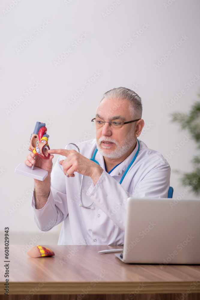 Old male doctor cardiologist working in the clinic Old male doctor cardiologist working in the clinic