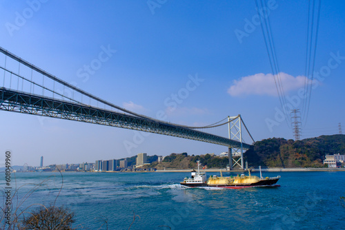 青空の関門橋と関門海峡を走る船 © doraneko777