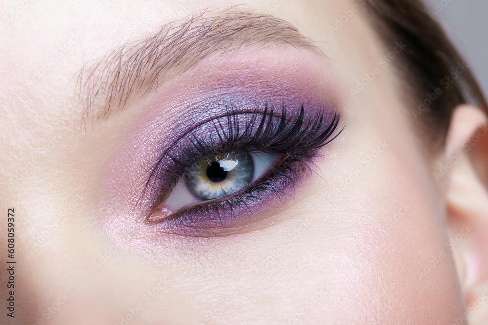 Obraz premium Closeup macro shot of human female eye. Woman with lilac beauty eyes makeup.