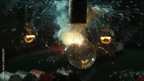 A lightbulb explodes in stunningly sharp, slow motion, which reveals bits of glass and filament. photo