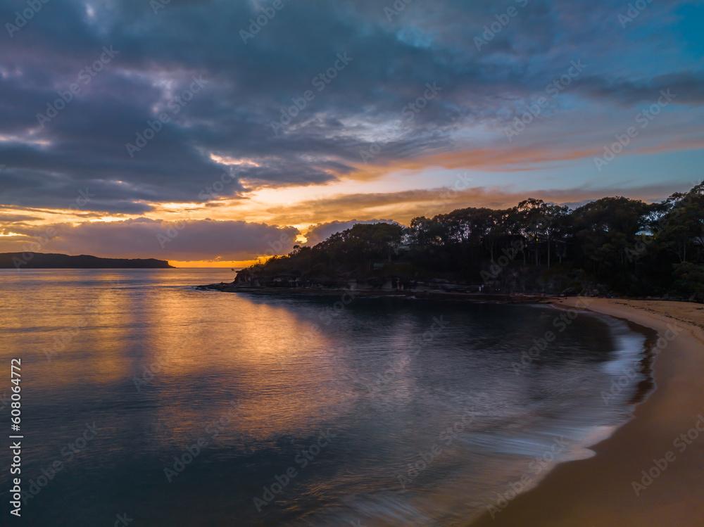 Fototapeta premium Aerial sunrise seascape with calm seas and a mix of high and low cloud
