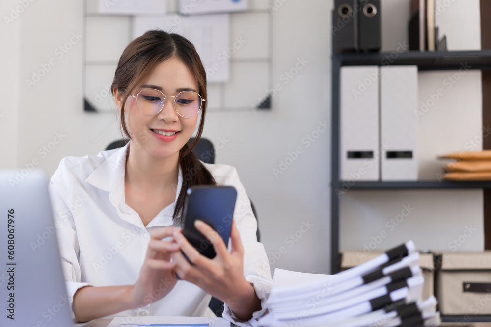 Business concept, Businesswoman reading business data on smartphone while sitting in modern office Business concept, Businesswoman reading business data on smartphone while sitting in modern office