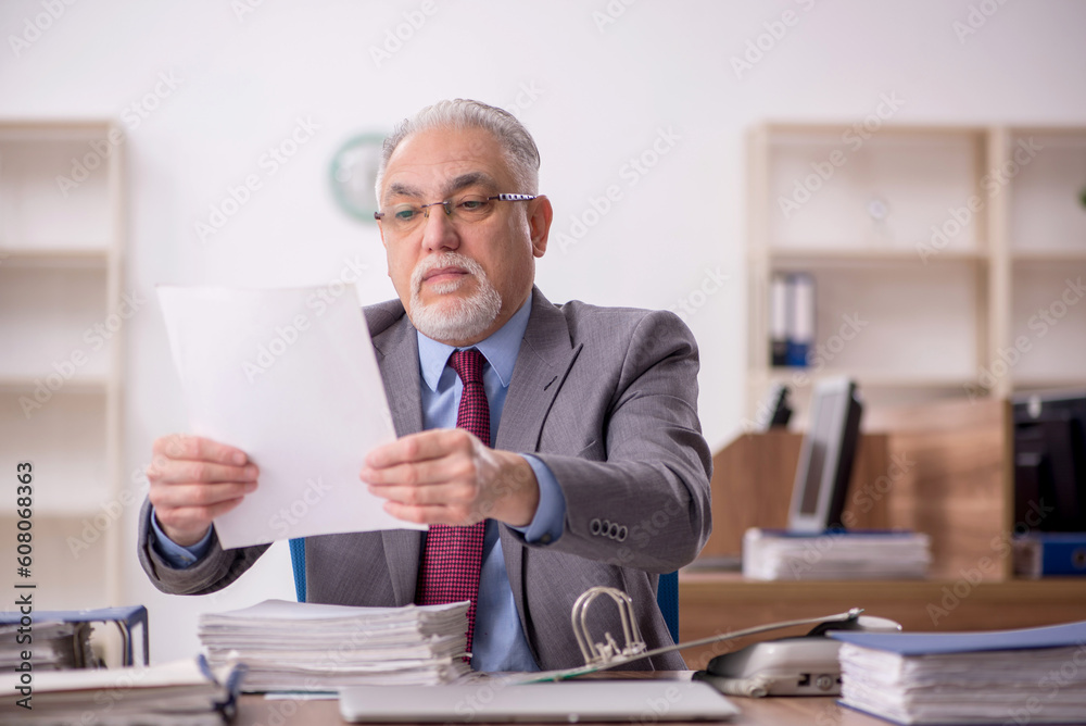Old male boss employee working in the office Old male boss employee working in the office