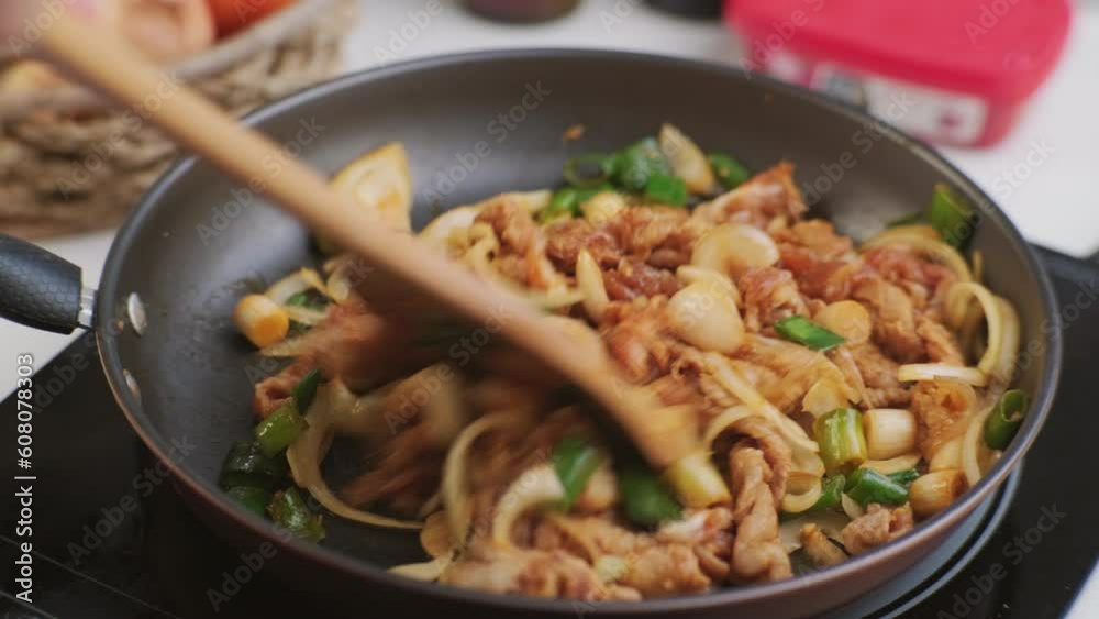 Cooking - Hands holding a ladle stir-frying kimchi and kurobuta pork in a wok in the kitchen. Korean homemade food for lunch Cooking - Hands holding a ladle stir-frying kimchi and kurobuta pork in a wok in the kitchen. Korean homemade food for lunch