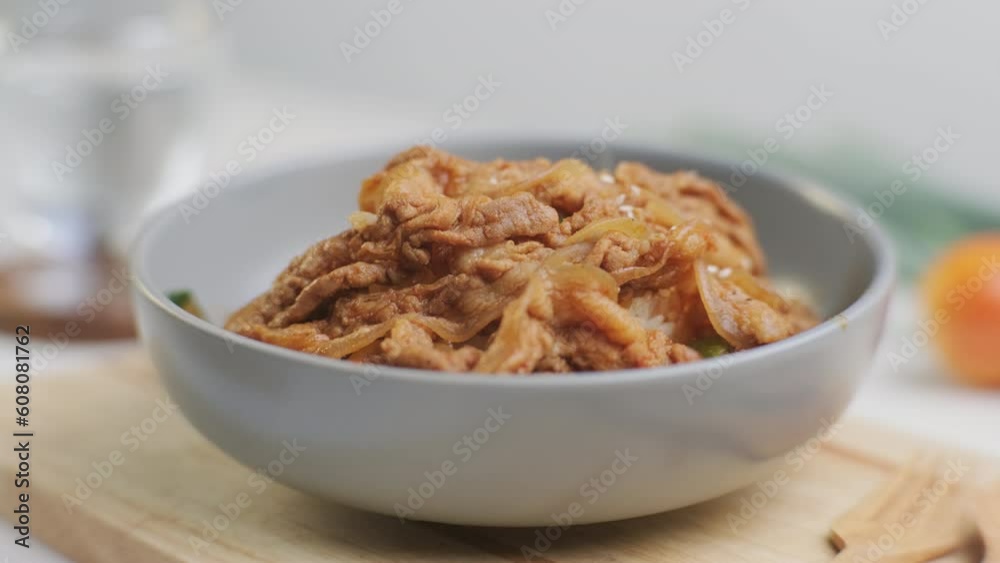 Fried kimchi with kurobuta pork on cooked rice in a bowl on wooden background. Korean food Fried kimchi with kurobuta pork on cooked rice in a bowl on wooden background. Korean food