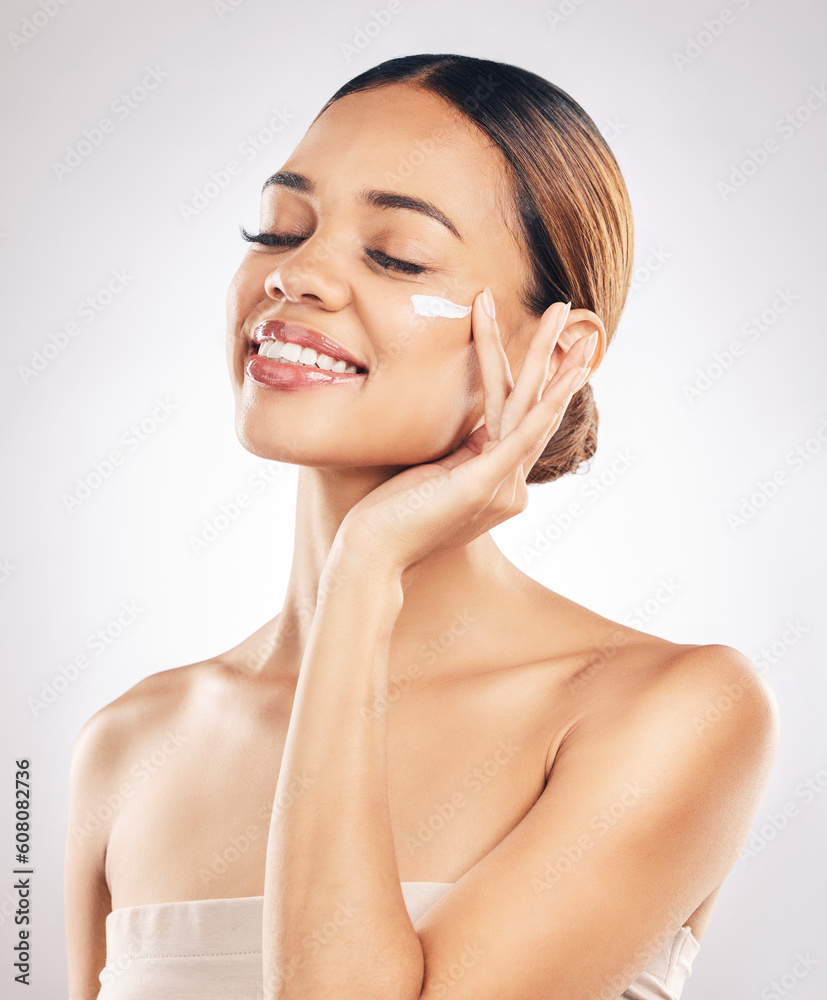 Woman with smile, cream on face and beauty, skincare and moisturizer isolated on studio background. Happy female model apply lotion, dermatology and cosmetic product with skin glow and facial