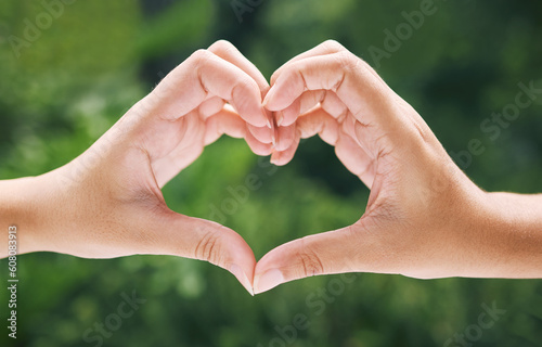 Hands, heart and emoji with eco friendly friends outdoor together in summer for love or solidarity. Social media, icon and hand gesture with people outside in nature for sustainability or bonding © Azeemud-Deen Jacobs/peopleimages.com