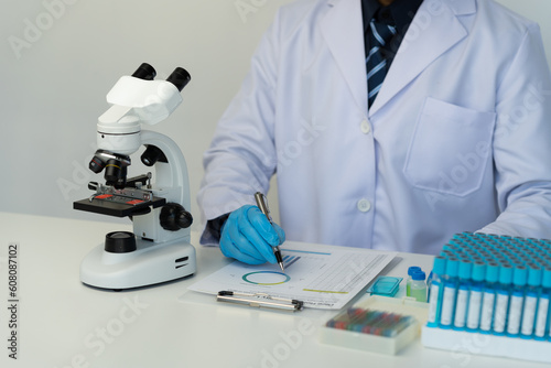Cropped view of male scientist recording data using pill sampling tubes for analysis and testing, advanced science laboratory for medicine biotechnology development of microbiology.
