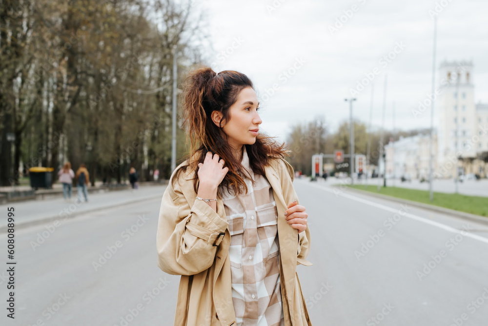 Young mixed race woman in raincoat posing outdoors looking away Young mixed race woman in raincoat posing outdoors looking away