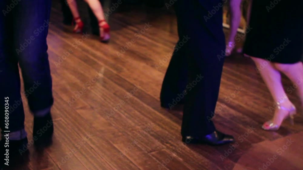 Argentine tango dancers dancing at a Tango party on a wooden parquet floor in an intimate and sensual atmosphere. Argentine tango dancers dancing at a Tango party on a wooden parquet floor in an intimate and sensual atmosphere.