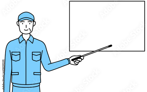 ホワイトボードを指示棒で指す帽子と作業着姿のシニア男性（経営者、管理職、上司）