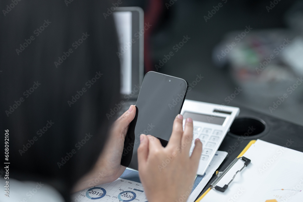 Young business woman on the phone at the office.Business woman texting on the phone and working on laptop.Beautiful young business woman sitting in office.Business woman smiling. Young business woman on the phone at the office.Business woman texting on the phone and working on laptop.Beautiful young business woman sitting in office.Business woman smiling.