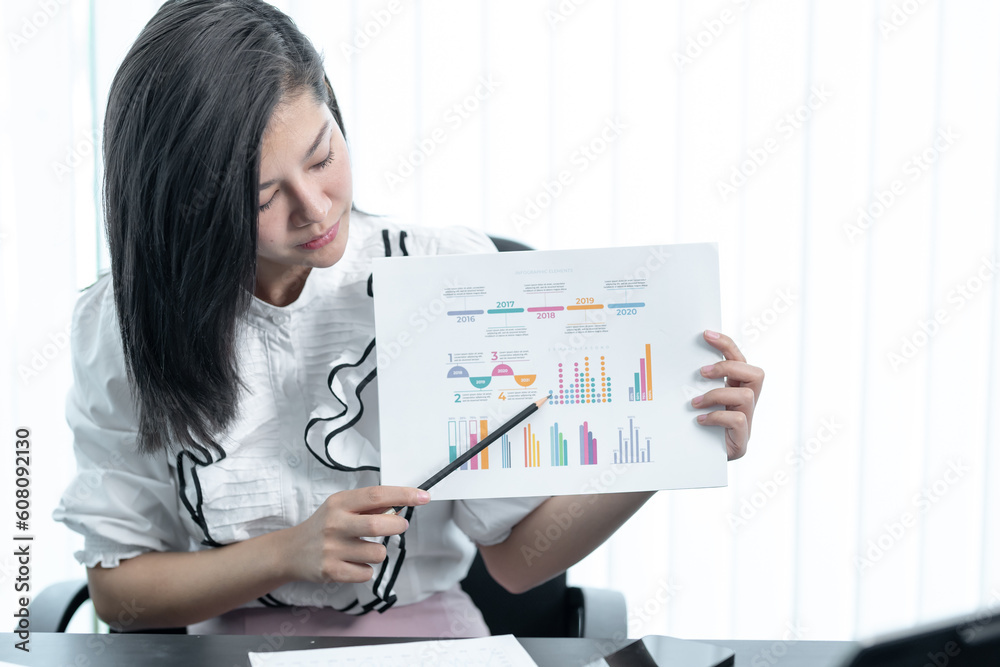 Young successful employee business woman white shirt hold paper account documents work stand at workplace white desk with laptop pc computer at light modern office indoors achievement career concept Young successful employee business woman white shirt hold paper account documents work stand at workplace white desk with laptop pc computer at light modern office indoors achievement career concept