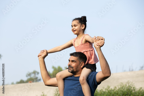 Indian father and daughter playing and carrying on back