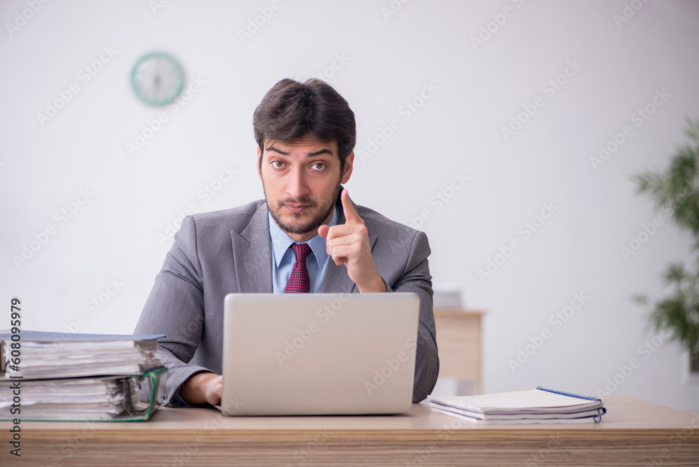 Young male employee sitting in the office Young male employee sitting in the office