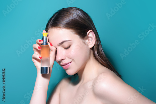 Perfume bottle. Woman with spray aroma perfume. Woman holding a perfumes bottle. Beautiful girl using perfume. Woman with bottle of perfume. Woman presents perfumes fragrance.