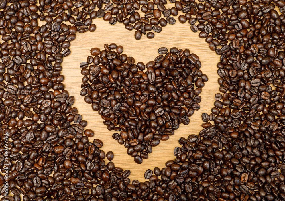 The whole coffee beans are photographed at the top corner and placed in the shape of a heart before being ground for drinking. The whole coffee beans are photographed at the top corner and placed in the shape of a heart before being ground for drinking.