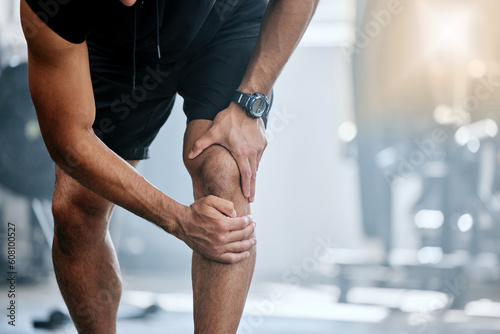 Fitness, gym and mockup, man with knee pain and medical emergency from workout injury at sports studio. Exercise, health and wellness, bodybuilder with hand on leg muscle ache for relief at training.