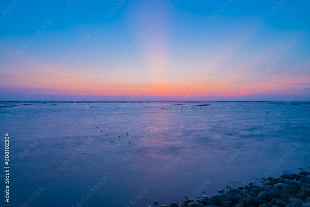 The sun was falling below the horizon during golden hour.The quite beautiful blue tone sunset at Tainan quigu of Taiwan.The long exposure photography of the fantastic hue of the sky and the sea. The sun was falling below the horizon during golden hour.The quite beautiful blue tone sunset at Tainan quigu of Taiwan.The long exposure photography of the fantastic hue of the sky and the sea.