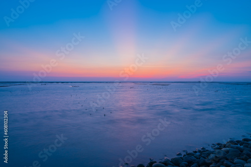 The sun was falling below the horizon during golden hour.The quite beautiful blue tone sunset at Tainan quigu of Taiwan.The long exposure photography of the fantastic hue of the sky and the sea.