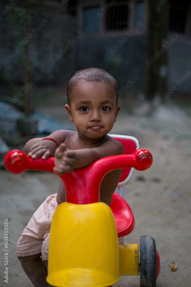 Cute little kid playing with a plastic made tricycle Cute little kid playing with a plastic made tricycle