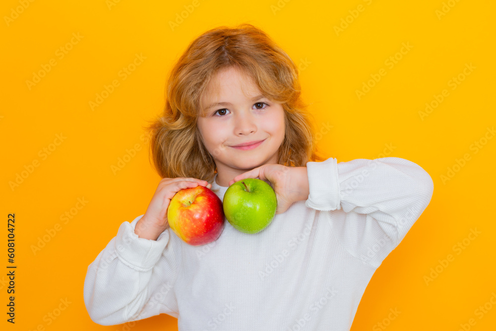 Kid with apple in studio. Studio portrait of cute child hold apple isolated on yellow background. Kid with apple in studio. Studio portrait of cute child hold apple isolated on yellow background.