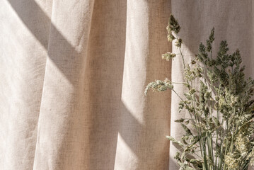 Aesthetic boho neutral floral background, abstract sunlight shadows on beige linen curtain and meadow grass, elegant business, interior or wedding design template