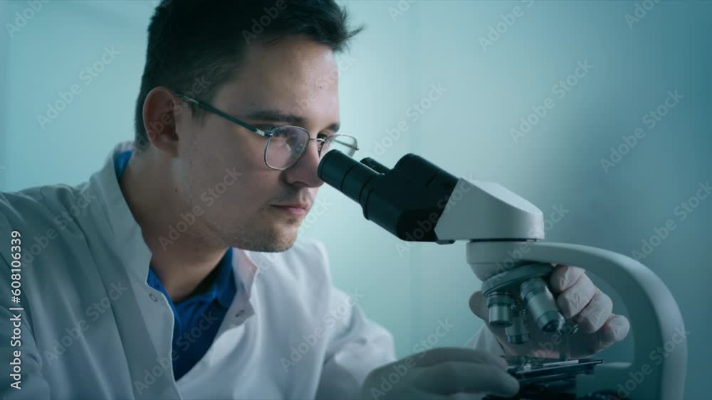 Close up engineer in uniform at progressive science lab 4K. Portrait of medical research scientist male conducting medical test experiments using microscope, analyzing samples in biological laboratory Close up engineer in uniform at progressive science lab 4K. Portrait of medical research scientist male conducting medical test experiments using microscope, analyzing samples in biological laboratory