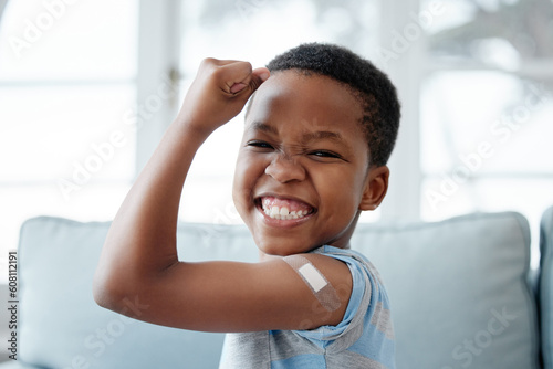 African boy kid, vaccine and portrait with smile, medicine and flex muscle for wellness in hospital. Male child, strong and excited with plaster for injection, healthcare and injection to stop virus photo