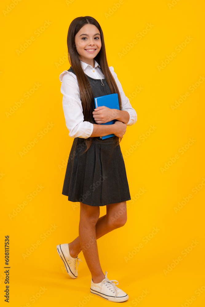 Back to school. Teenager schoolgirl with book ready to learn. School girl children on isolated yellow studio background. Back to school. Teenager schoolgirl with book ready to learn. School girl children on isolated yellow studio background.