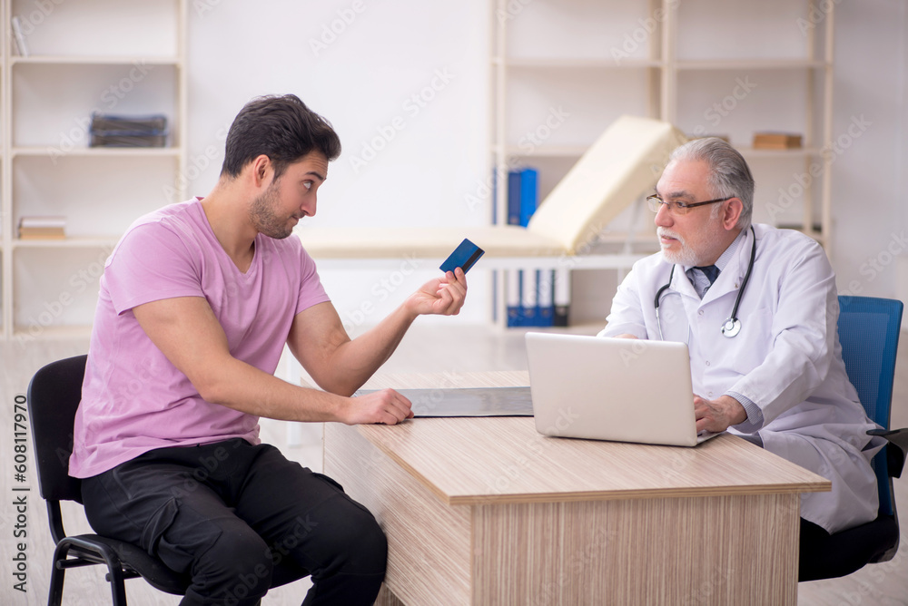 Young male patient visiting old male doctor Young male patient visiting old male doctor