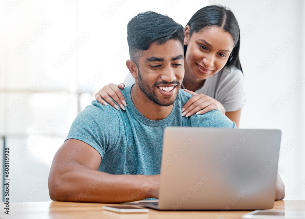 Couple, laptop and Indian man in a home with online shopping and ecommerce app with wife support. Mockup, young people and happiness from promotion email in a house at desk with woman supporting