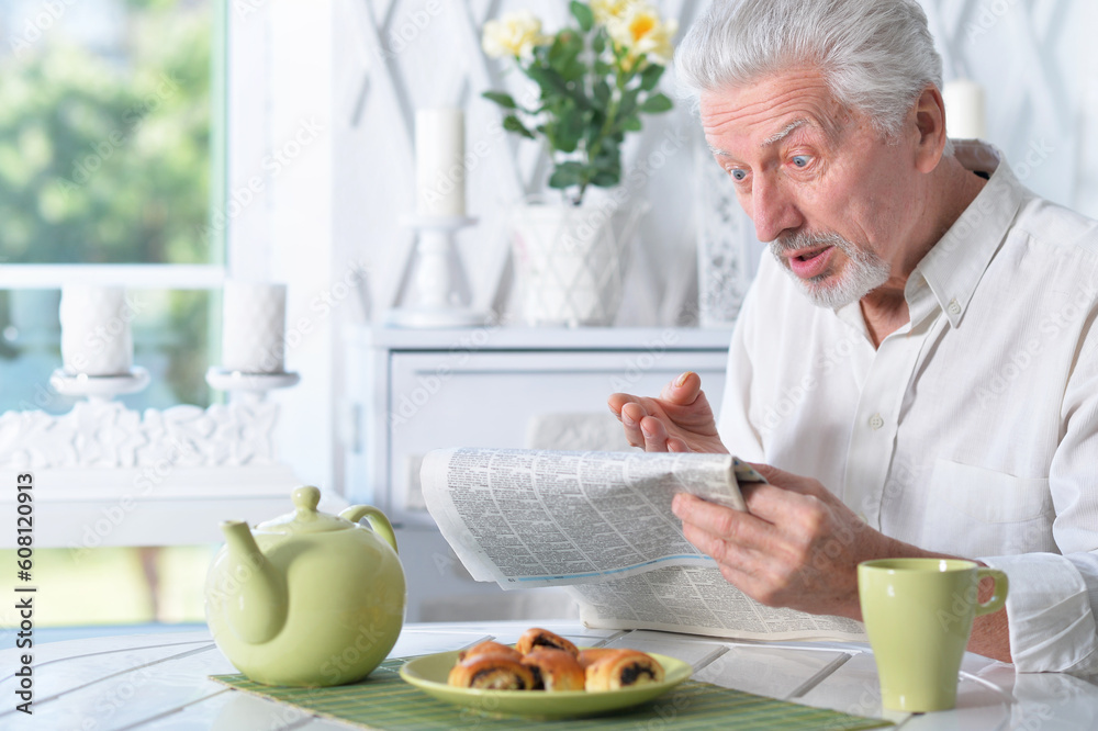 Emotional senior man reading newspaper Emotional senior man reading newspaper