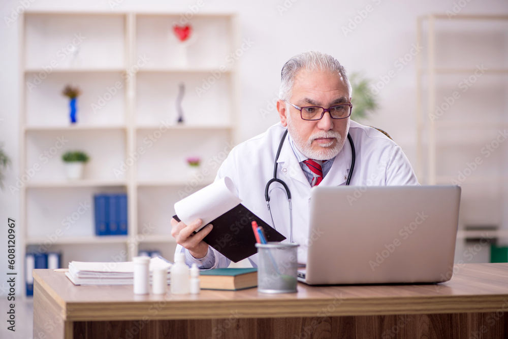 Old male doctor in telemedicine concept