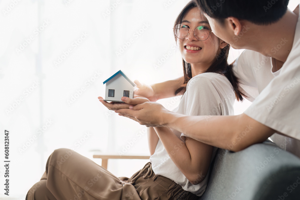 Happy asian family young couple holding house bank to save for saving money wealth to buy real estate for new home. Financial planning, business finance concept Happy asian family young couple holding house bank to save for saving money wealth to buy real estate for new home. Financial planning, business finance concept