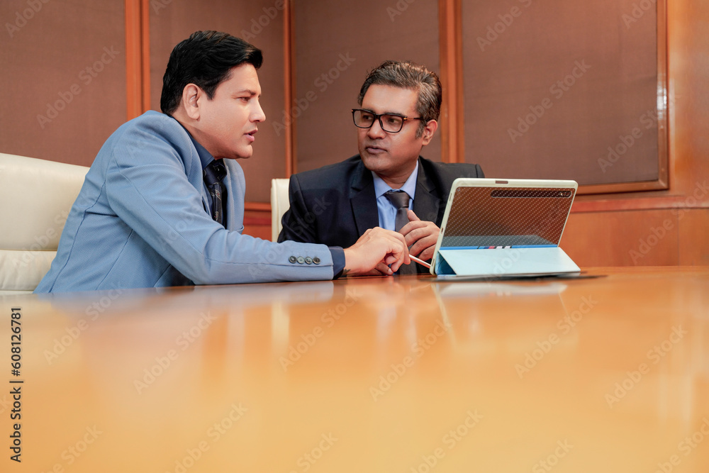 Two indian businessman discussing and using digital tablet Two indian businessman discussing and using digital tablet