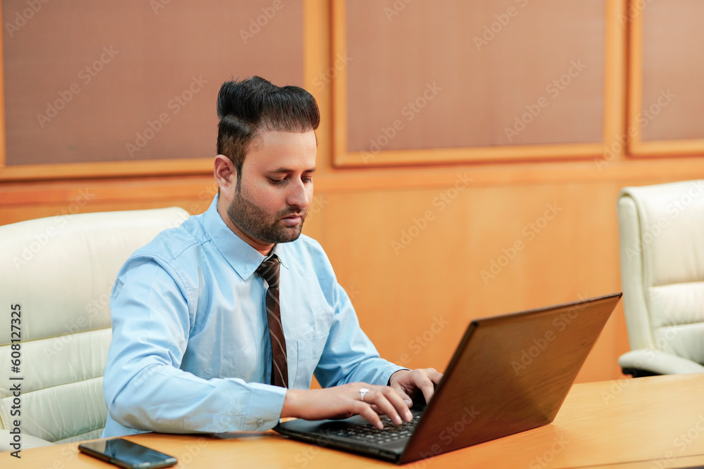 Indian businessman using laptop at office. Indian businessman using laptop at office.