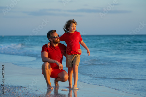 Father and son hugging on the beach at the day time. Friendly family. Fathers day. Love family, father and a son walk together in sea nature on beach vacation. Parenting, fatherhood, fathers love.