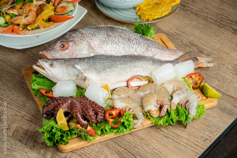 Fresh raw fish decorated with shrimps and fresh lettuce Fresh raw fish decorated with shrimps and fresh lettuce