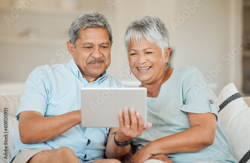 Technology, senior and couple with tablet happy on sofa in living room of their home. Connectivity or social networking, cheerful and smile with married people on couch streaming movie for retirement