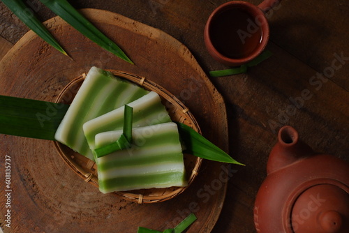 kue lapis and tea pot in wooden background 