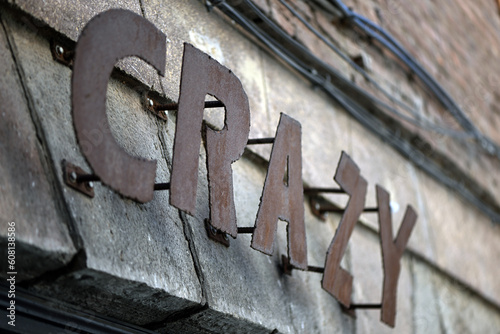 The word "crazy" in metal letters on an old house wall in Spain.