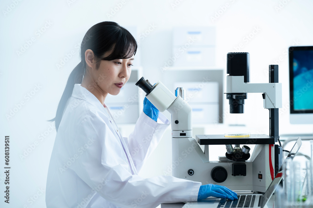 A female scientist conducting research under a microscope A female scientist conducting research under a microscope